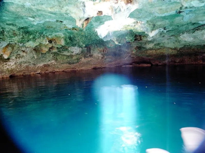 Rayos de luz atravesando el agua azul de un cenote